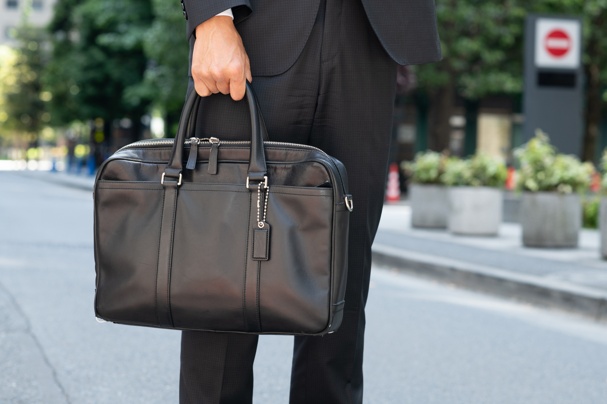 黒いビジネスバッグを手に持つ男性の画像